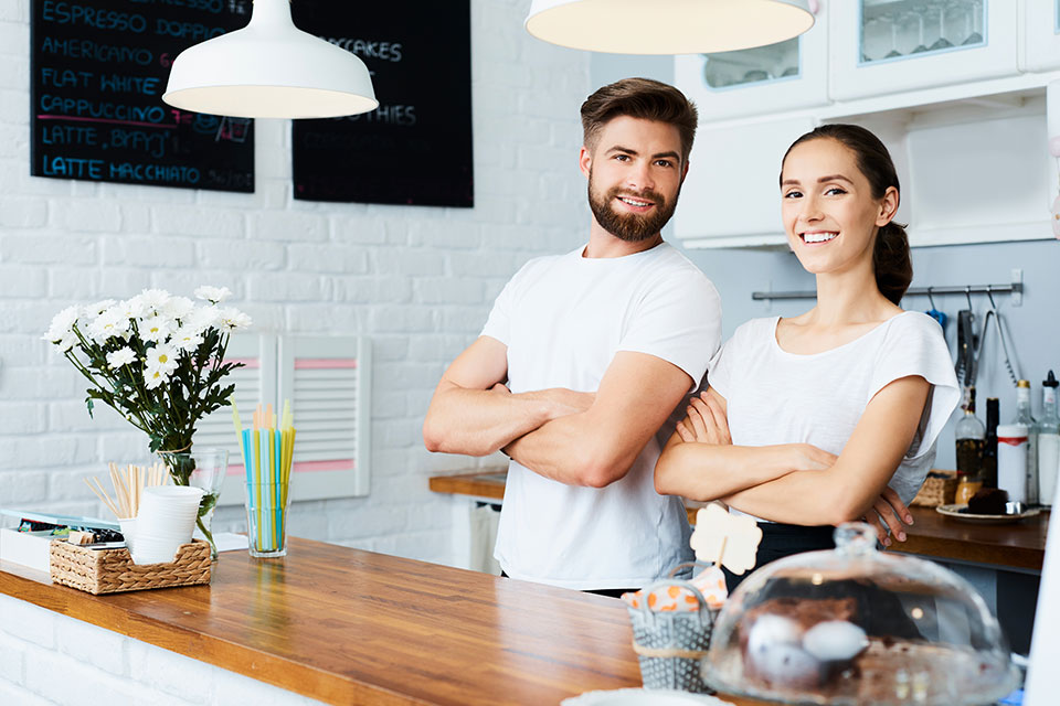 man and woman standing behind table in kitchen